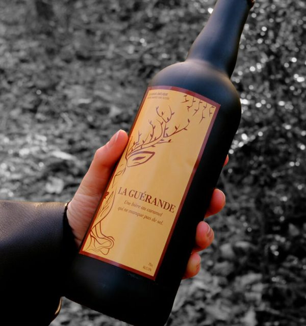 Une main tient la bière La Guérande, une bière artisanale au caramel et sel de Guérande par Le Gouel Gaélique.